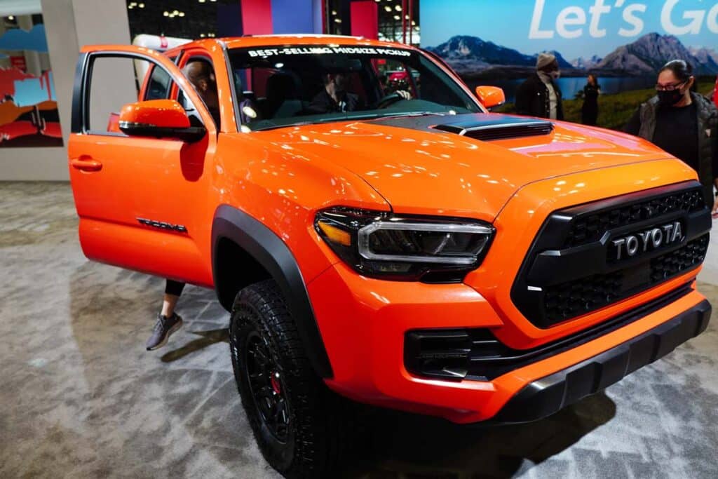 An orange 2023 Toyota Tacoma at a car show, representing the Toyota Tacomas recall.