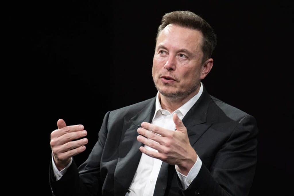A photo of Elon Musk at a speaking event, representing the Elon Musk and OpenAI lawsuit.