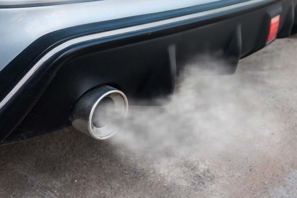 Close up of a car tailpipe emitting exhaust, representing the tailpipe pollution rules.