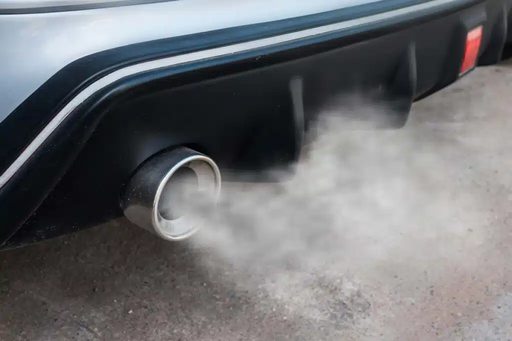 Close up of a car tailpipe emitting exhaust, representing the tailpipe pollution rules.