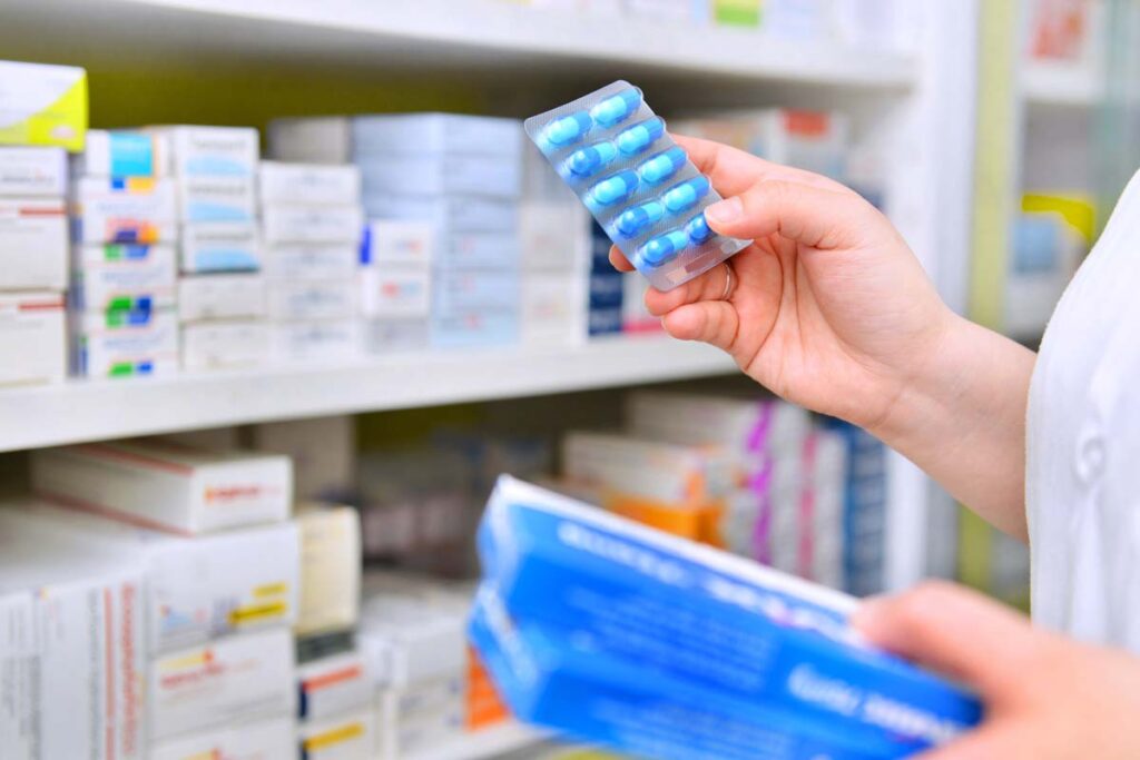 Close up of a pharmacist holding medicine, representing the Sandoz drug price-fixing settlement.