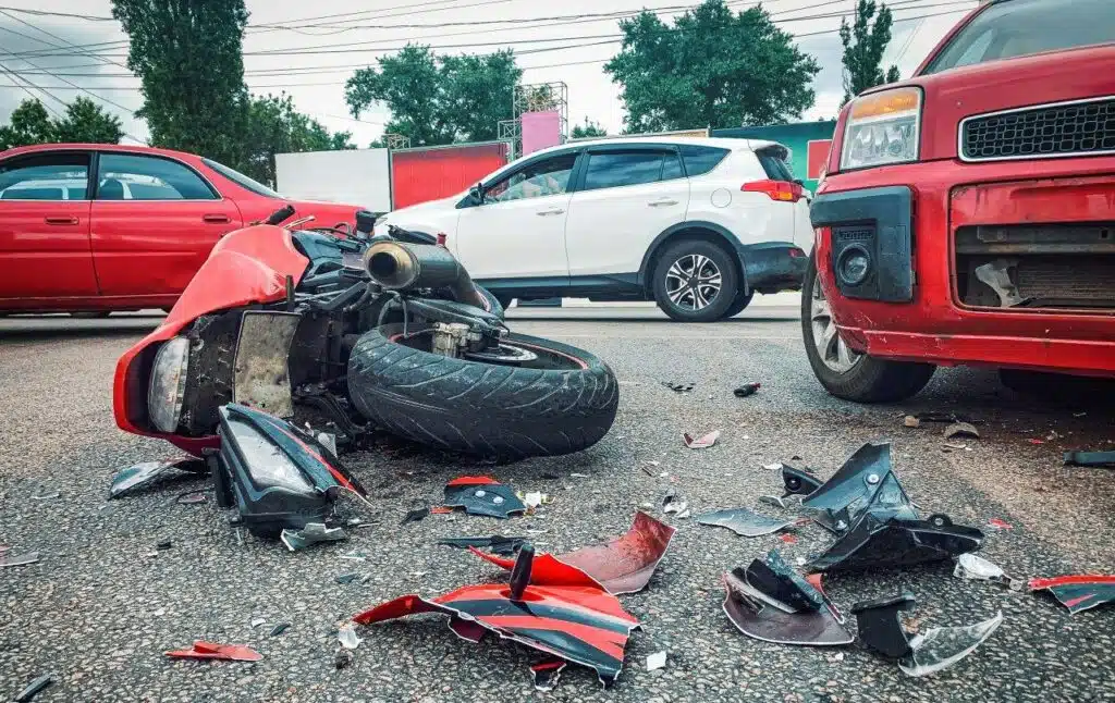 Motorcycle bike accident and car crash, broken and wrecked motorcycle on road