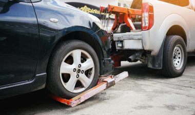 A tow truck repossessing a car, representing the Nicholas Financial debt-collection settlement.