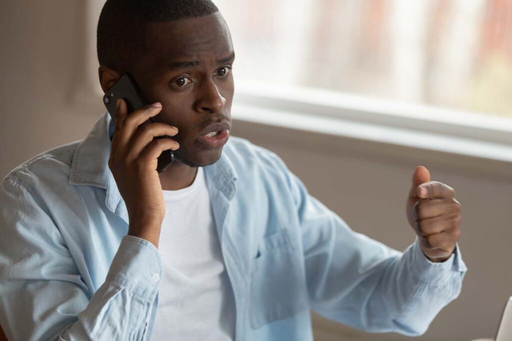 Close up of an irritated man on the phone, representing the CallCore Media TCPA settlement.