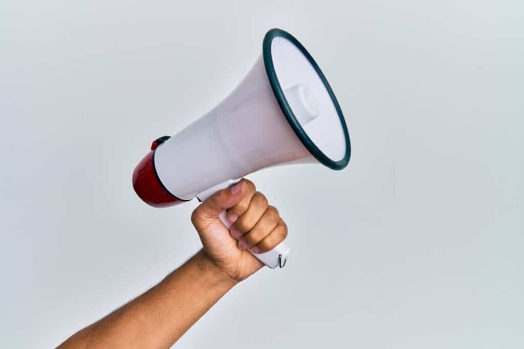 Close up of a hand holding a megaphone, representing top recalls for the week of April 15.