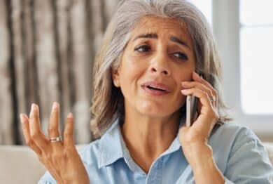 Frustrated Woman Receiving Unwanted Telephone Call At Home