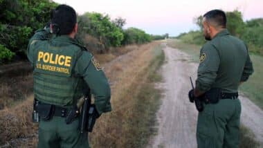 Two male border patrol agents consulting with each other, representing the Texas migrant arrest law.