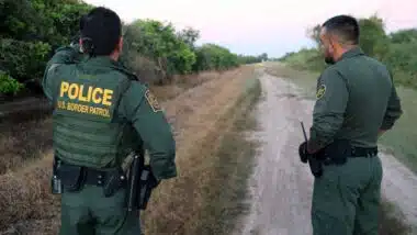 Two male border patrol agents consulting with each other, representing the Texas migrant arrest law.