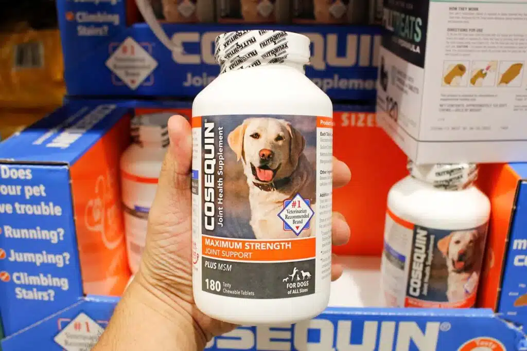 Close up of a hand holding a bottle of Cosequin inside a supermarket, representing Nutramax cosequin class action lawsuit.