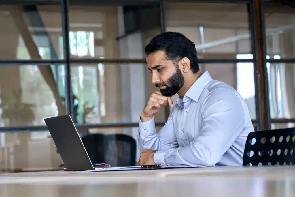 A man reading a publication on his laptop, representing the Charter Financial settlement.