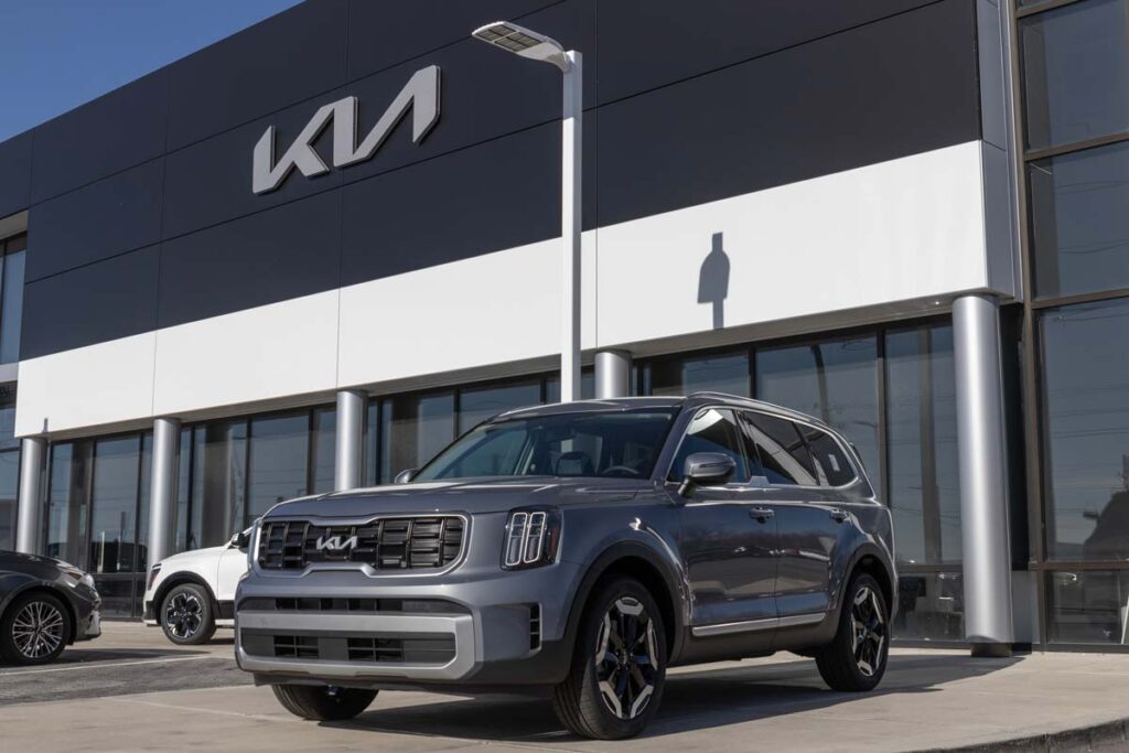 A gray Kia Telluride in front of a Kia dealership, representing the Kia Telluride recall.