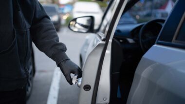 Close up of a car thief in all black opening a car door, representing Hyundai Kia car theft class action.