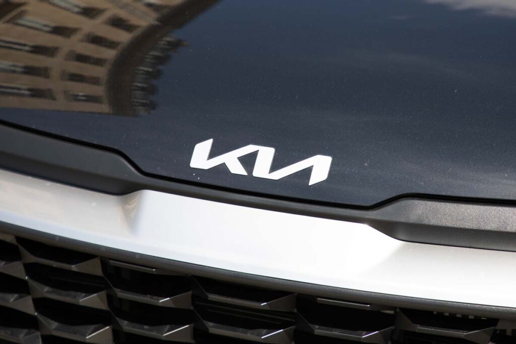 Close up of Kia emblem on a front bumper, representing the Kia class action.