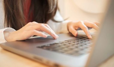 Close up of a womans hands using a laptop, representing the Pillow Cube class action.