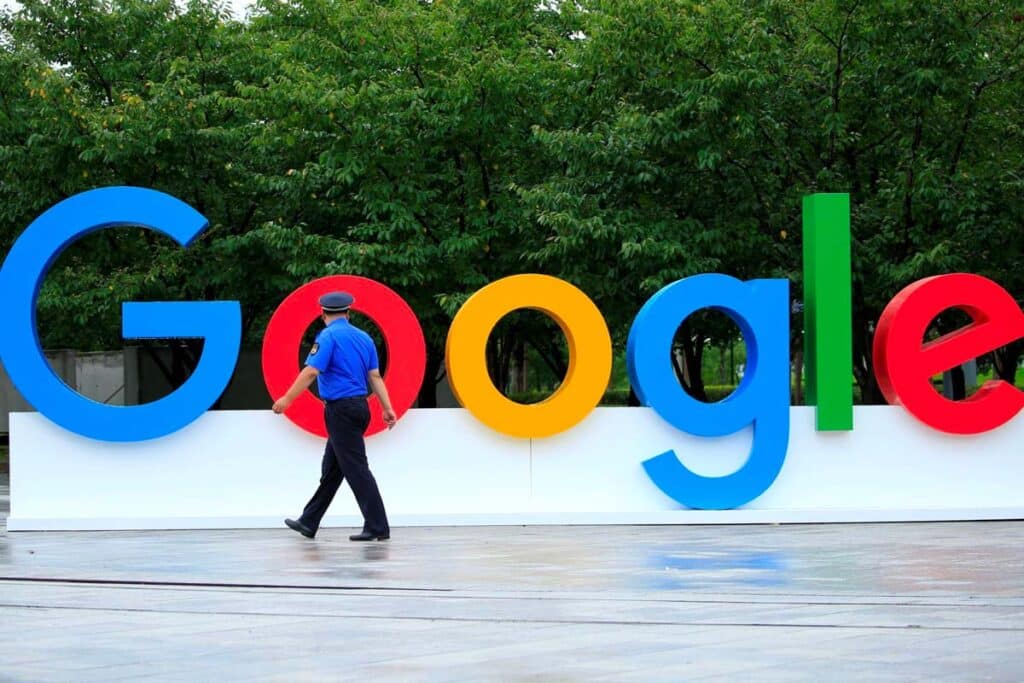 A security guard walking in front of large Google signage, representing Google data class action lawsuit.