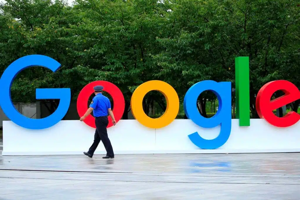 A security guard walking in front of large Google signage, representing Google data class action lawsuit.