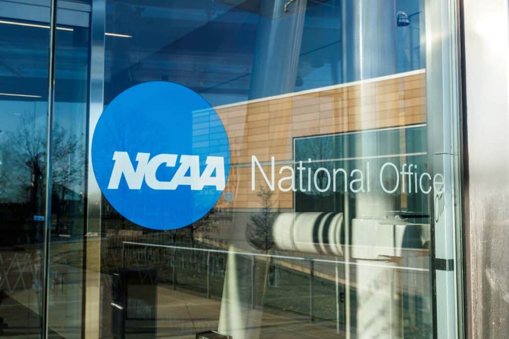 Close up of NCAA National Office signage on a glass door, representing the NCAA NIL lawsuit.