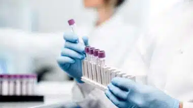 Close up of a lab technician putting test tubes into a holder, representing the FDA lab tests regulation.