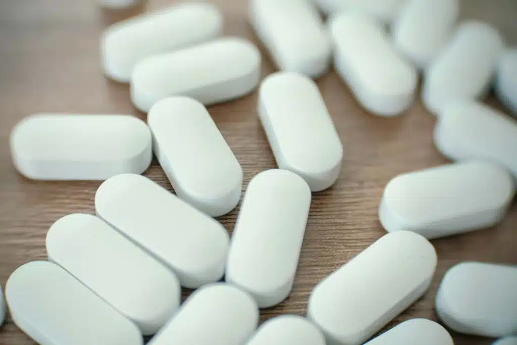 Close up of white pills on a table, representing the Amneal Pharmaceuticals opioid settlement.