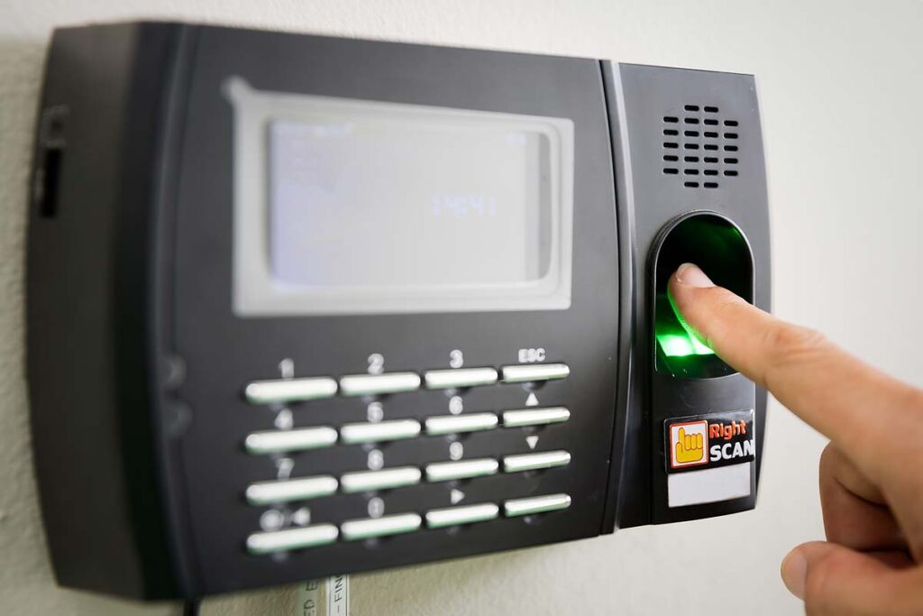 Close up of a woman scanning her finger on a time clock, representing the NOVAtime BIPA settlement.