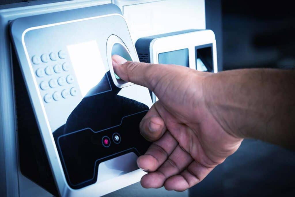 Close up of a man scanning his fingerprint on a time clock, representing the Vonachen Services settlement.