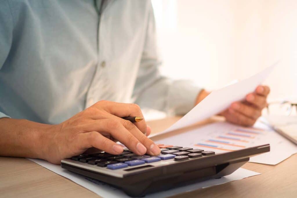 Close up of a man using a calculator, representing the Antigua Club fees settlement.