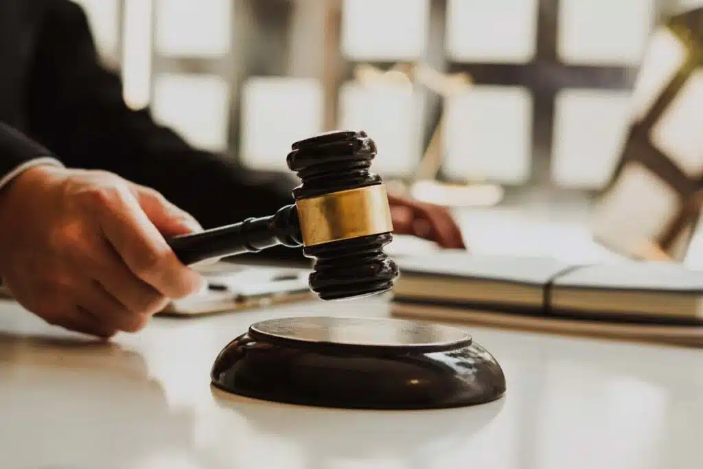 Close up of a judges hands holding a wooden gavel, representing employment lawsuits.