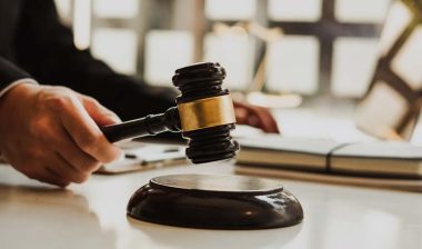 Close up of a judges hands holding a wooden gavel, representing employment lawsuits.