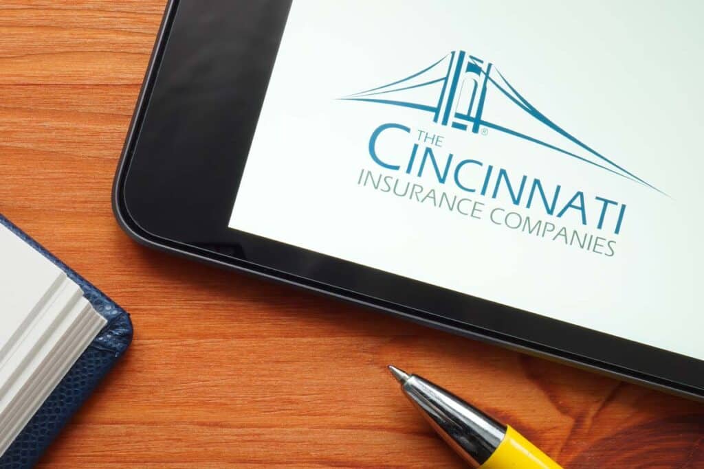 Cincinnati Insurance Companies logo displayed on a tablet next to a pen and journal, representing the Cincinnati Insurance settlement.