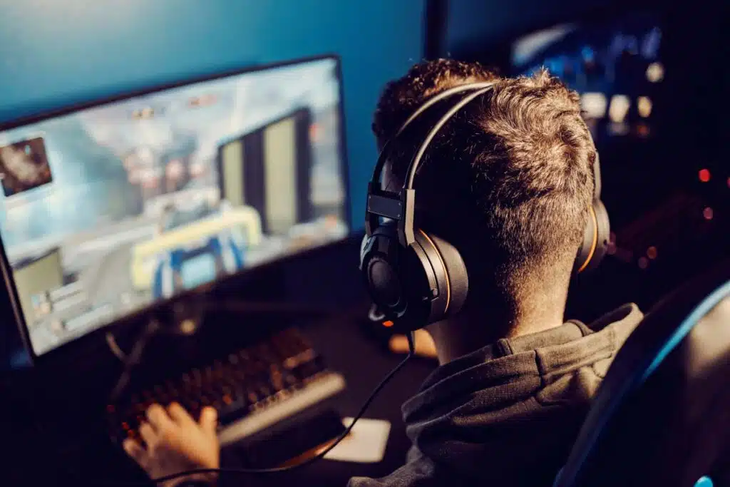 Back view of a young man playing a video game on his computer, representing the video game lawsuit.