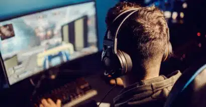 Back view of a young man playing a video game on his computer, representing the video game lawsuit.