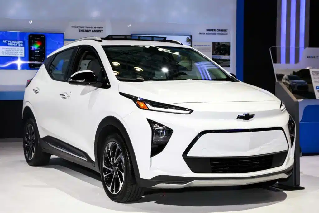 A white Chevrolet Bolt on display at a car show, representing the Chevy Bolt battery overheating settlement.