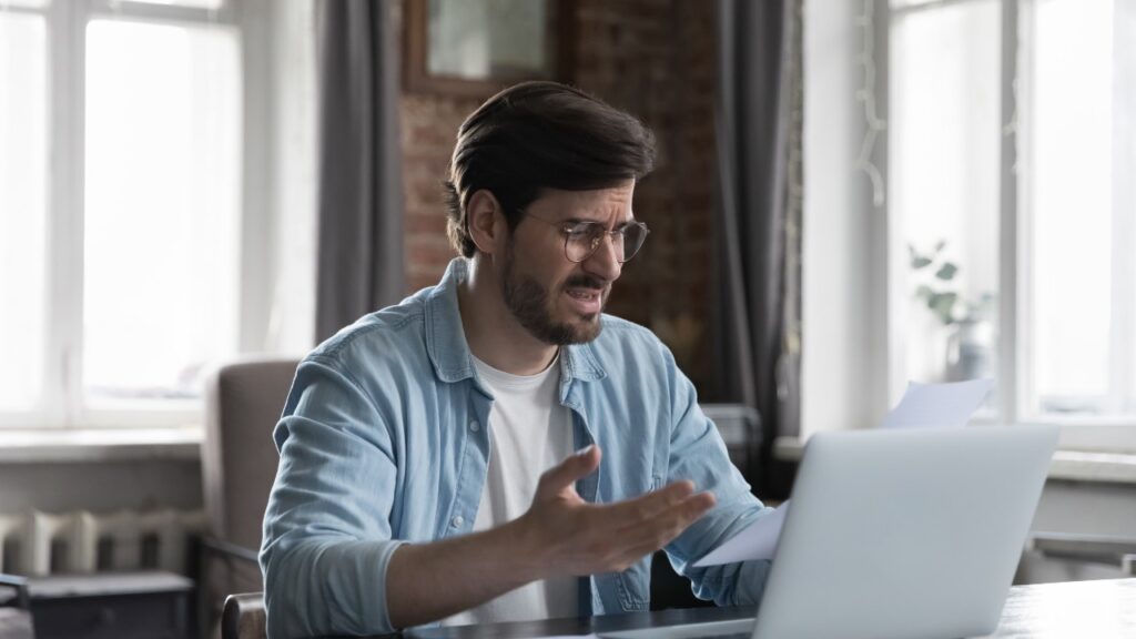 Bank fees have a man upset while doing finances.