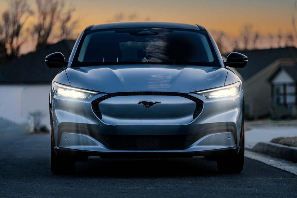 Front view of a silver Ford Mustang Mach-E in front of a sunset, representing the Ford Blue Cruise investigation.