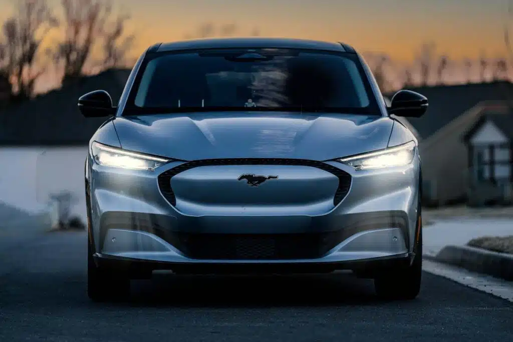 Front view of a silver Ford Mustang Mach-E in front of a sunset, representing the Ford Blue Cruise investigation.