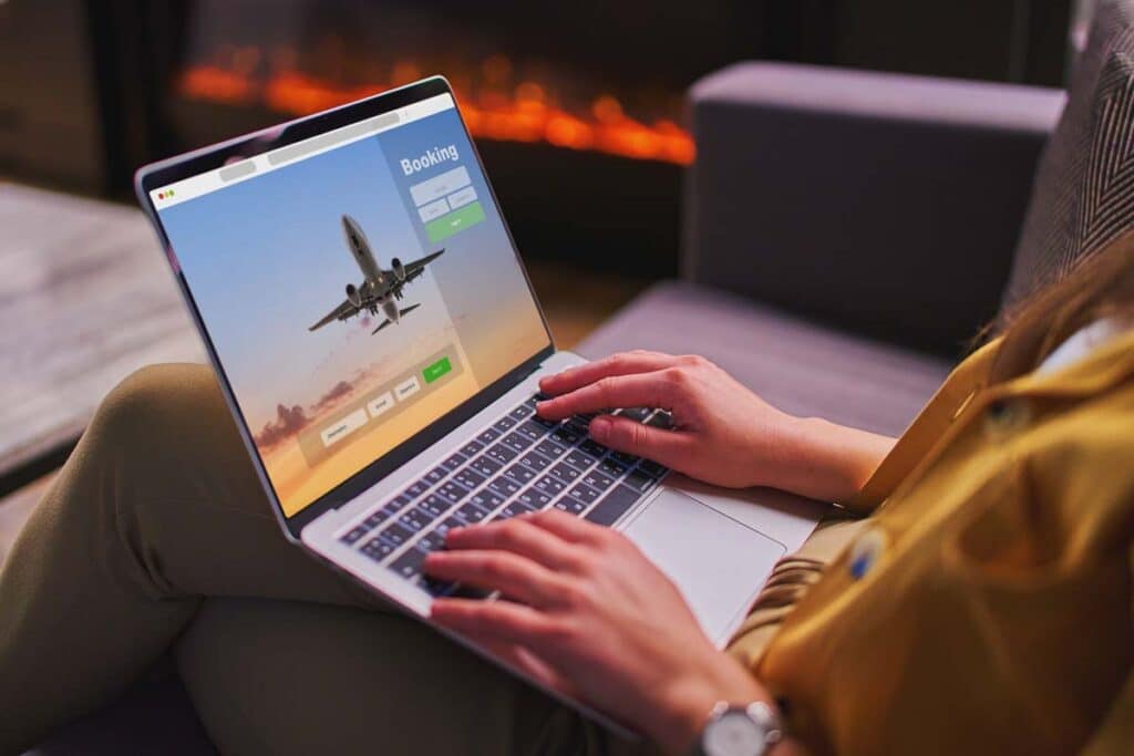 Close up of a woman booking a flight on a laptop, representing the airlines lawsuit.