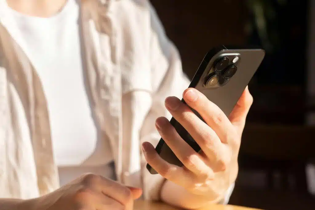 Close up of a womans hands holding a smartphone, representing the TJX class action.