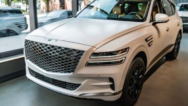 Front of a white Genesis GV80 in a showroom, representing the Hyundai Genesis recall.