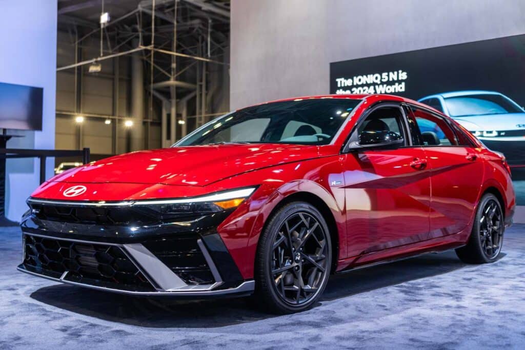 A red Hyundai Elantra on display in a large room, representing the Hyundai recall.
