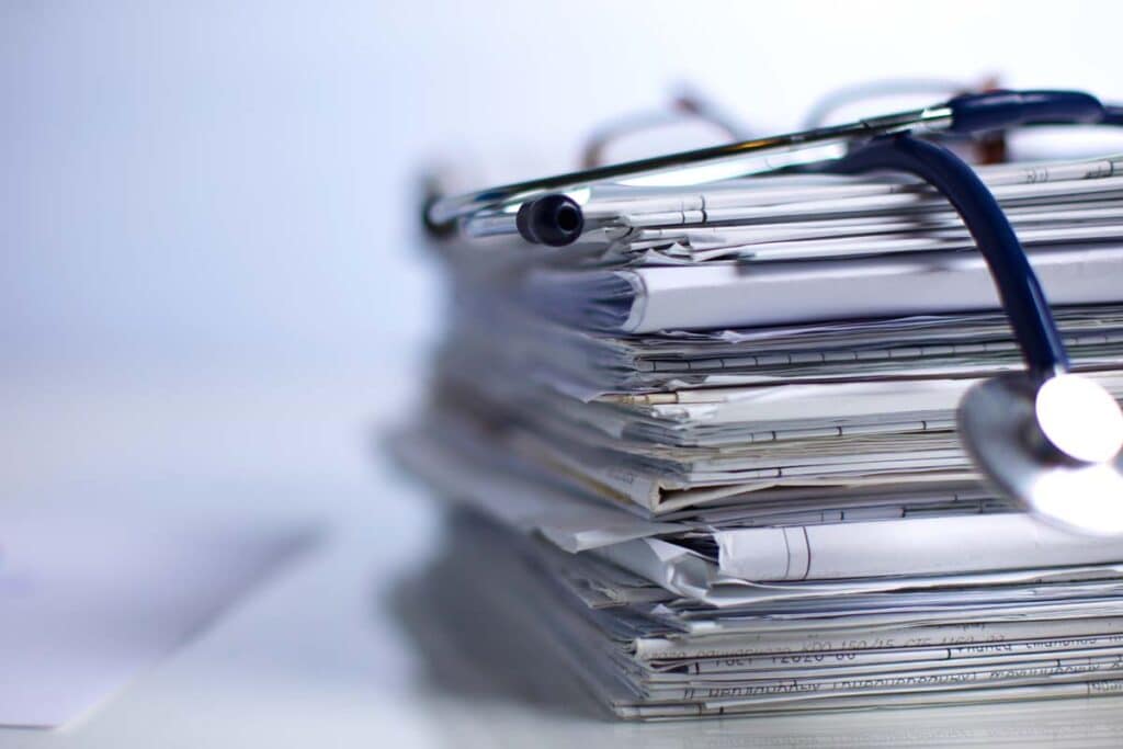 Close up of a stethoscope on top of a stack of medical records, representing the Verisma Systems settlement.