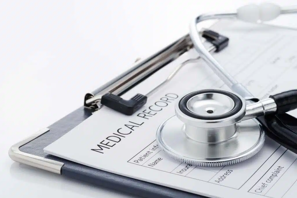 Close up of a medical records form with a stethoscope on top, representing the West Virginia medical record fee settlement.
