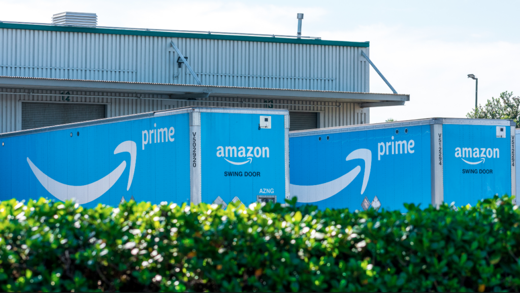 Amazon Prime delivery trucks loading and unloading online purchases at receiving dock of Amazon Fulfillment Center - Newark, California, USA