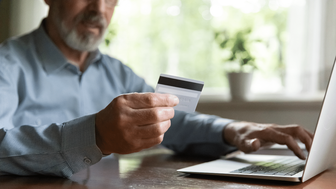 Man using prepaid debit card to order online.