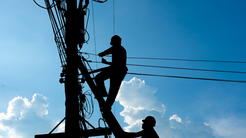 Workers working on telephone poles, representing the Pacific Bell settlement.