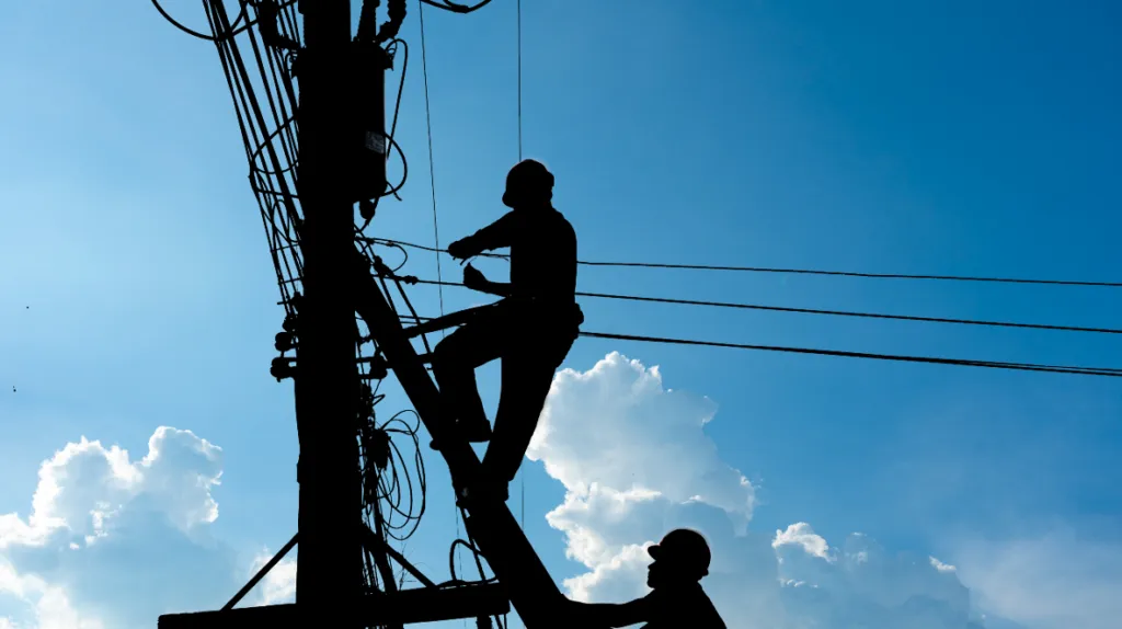 Workers working on telephone poles, representing the Pacific Bell settlement.