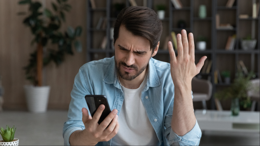 Upset man getting unwanted calls, representing the JK Buick settlement.