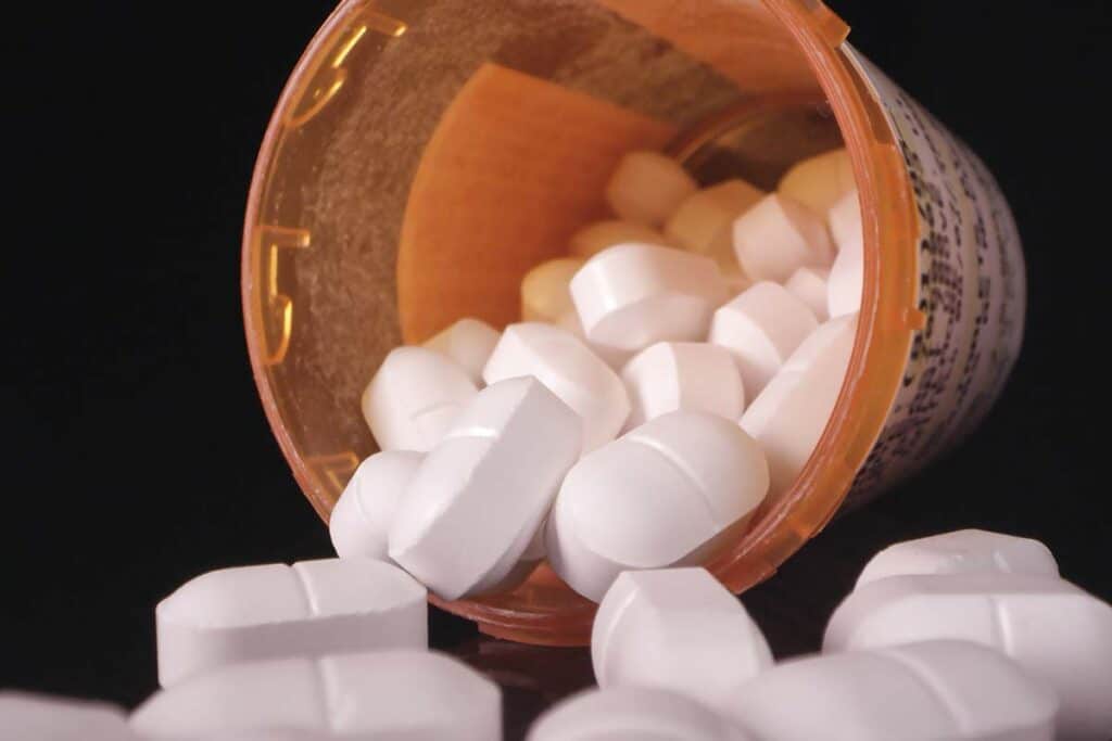 Opioid pills spilling out of a pill bottle, representing the Allergan settlement.