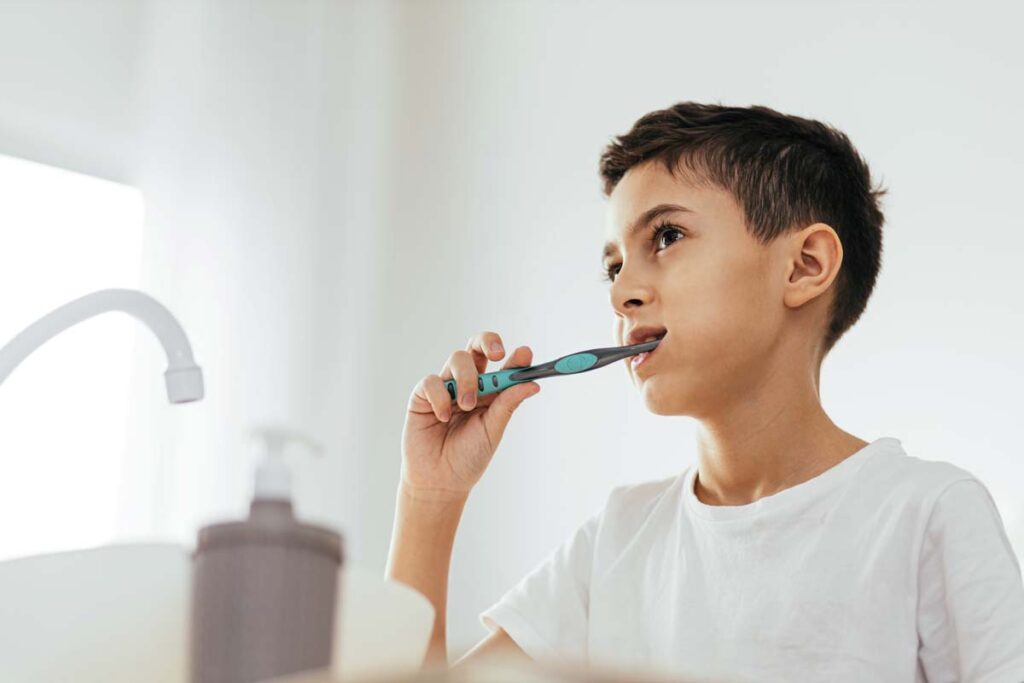 A young boy brushing his teeth, representing the toothpaste PFAS class action.