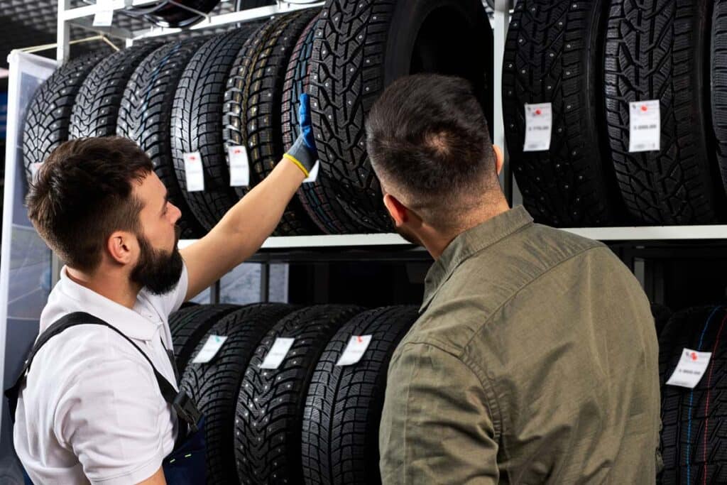A tire shop worker speaking with a customer, representing the tire price-fixing class actions.