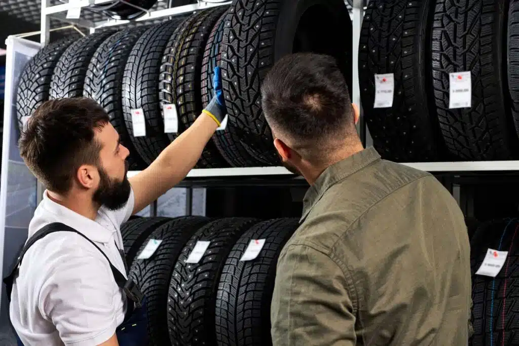 A tire shop worker speaking with a customer, representing the tire price-fixing class actions.
